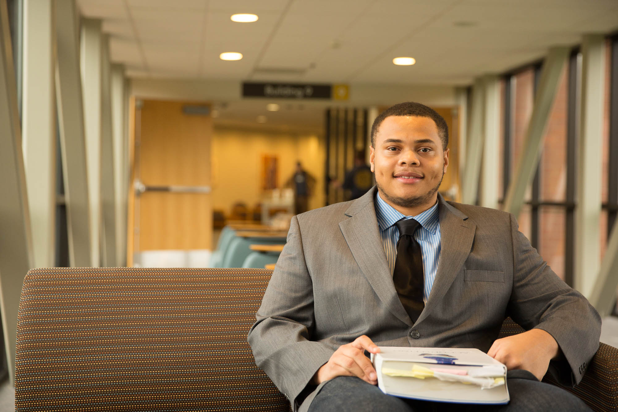 Student in a suit sitting down